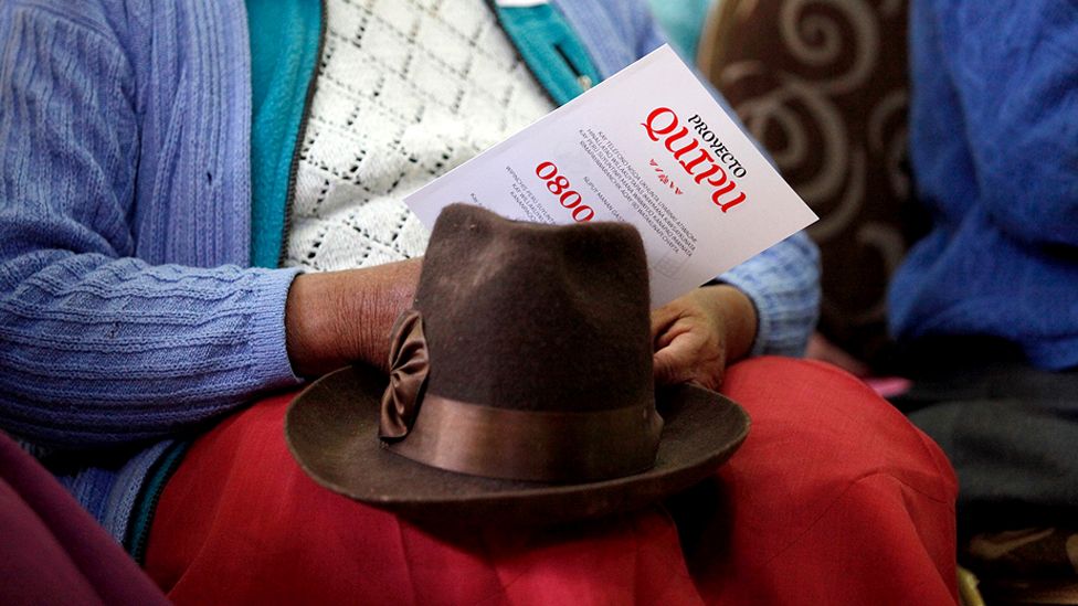 A Peruvian woman holding a Quipu flyer