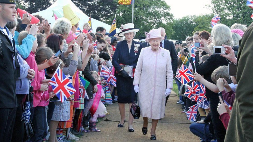 The Queen walking through a crowd of well-wishes