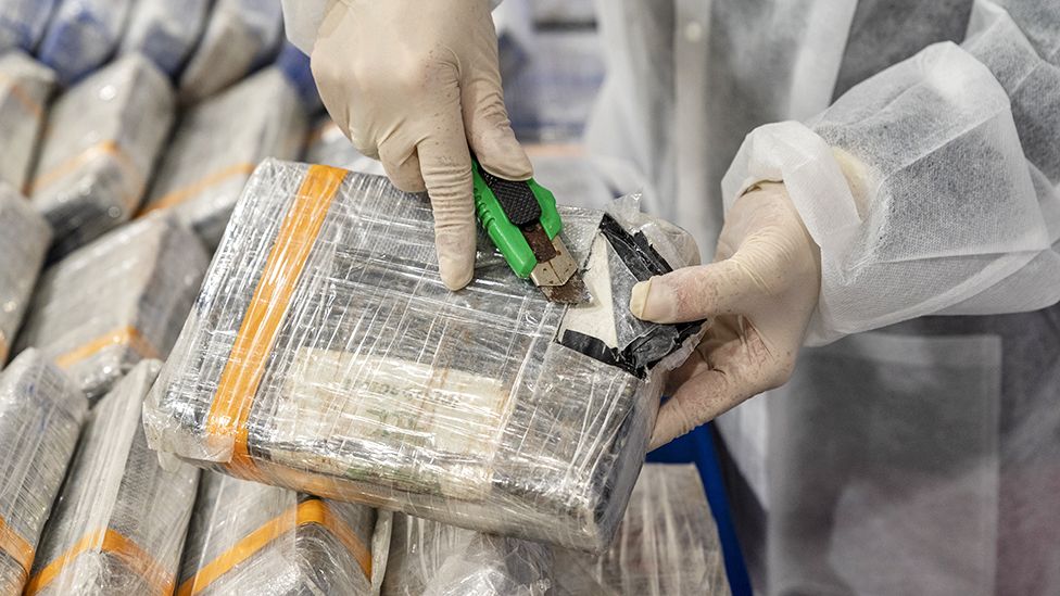 A police officer opens one of the 1 kg cocaine bricks shown during a press conference given by the Director of the Judicial Police National Unit to Combat Drug Trafficking, on March 05, 2020 in Lisbon, Portugal