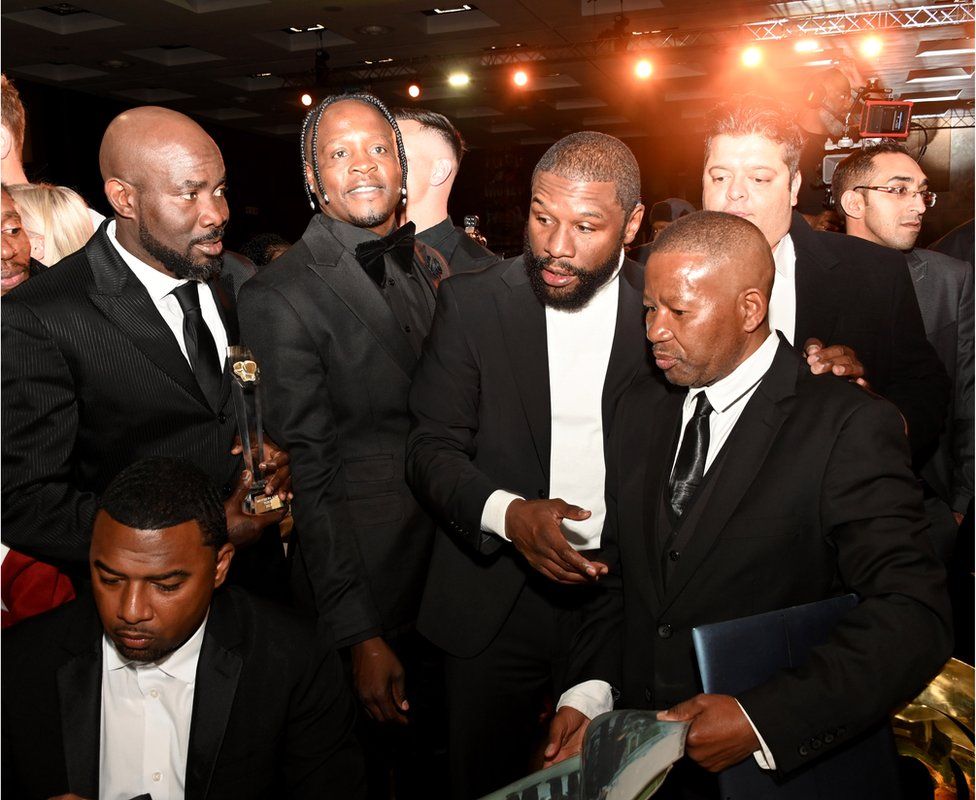 Floyd Mayweather at a black tie event surrounded by other sportsmen