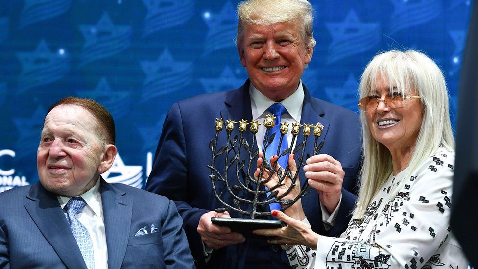 US President Donald Trump poses with Sheldon Adelson (L) and his wife Miriam Adelson ahead of his sddress ro the Israeli American Council National Summit 2019 at the Diplomat Beach Resort in Hollywood, Florida on December 7, 2019