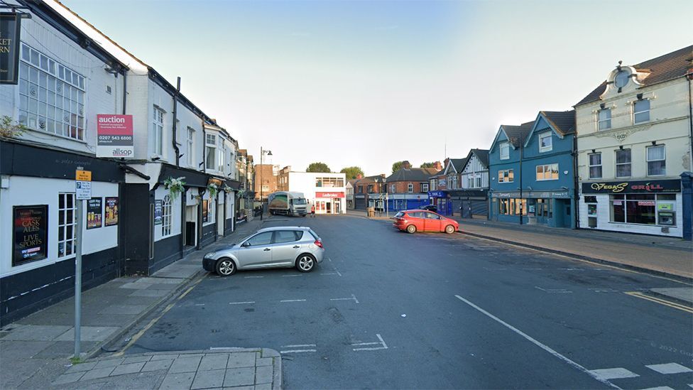 The current market square with a car park in front of all the shops