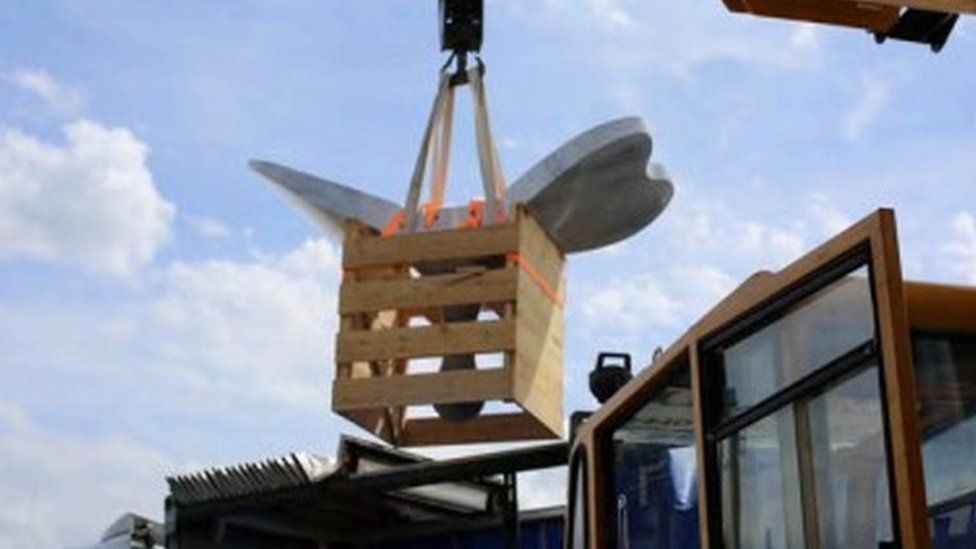 The sculpture is loaded in crates
