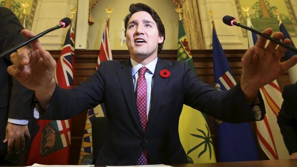 Justin Trudeau holds two microphones