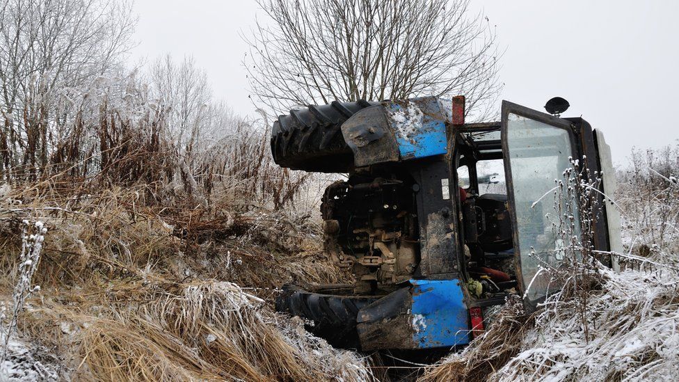 A tractor on its side in a ditch