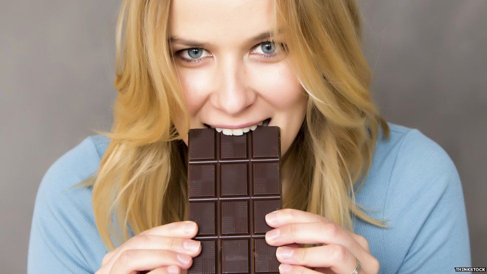 Woman tucks into large chocolate bar