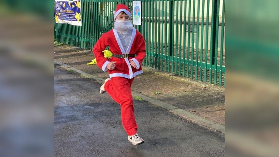 Oliver running in Santa suit