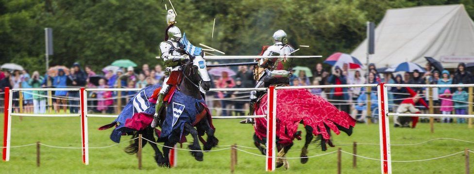 Competitors charging at a jousting tournament