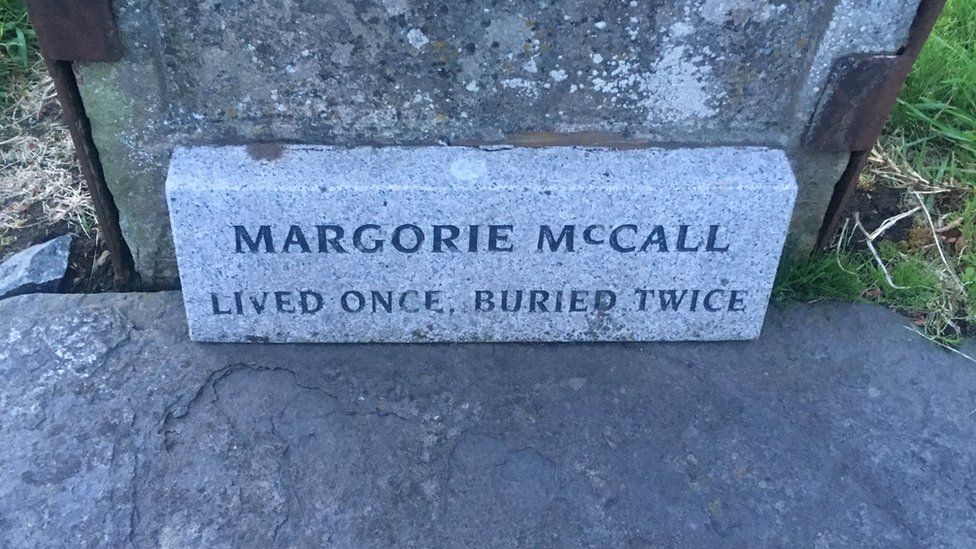 grave of Margorie McCall which says - Lived once, buried twice