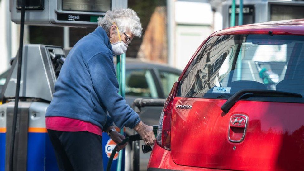 Женщина заправляет машину бензином