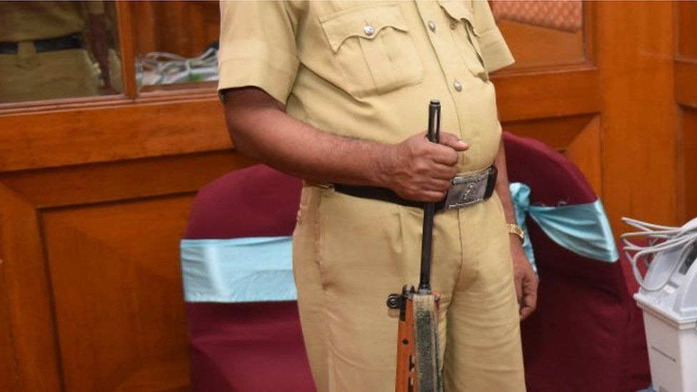 A police constable stands guard beside Voter-Verified Paper Audit Trail (VVPAT) machine during a demo session by the Election Commission of India to the media at a city hotel, on March 26, 2018 in Bengaluru, Indi