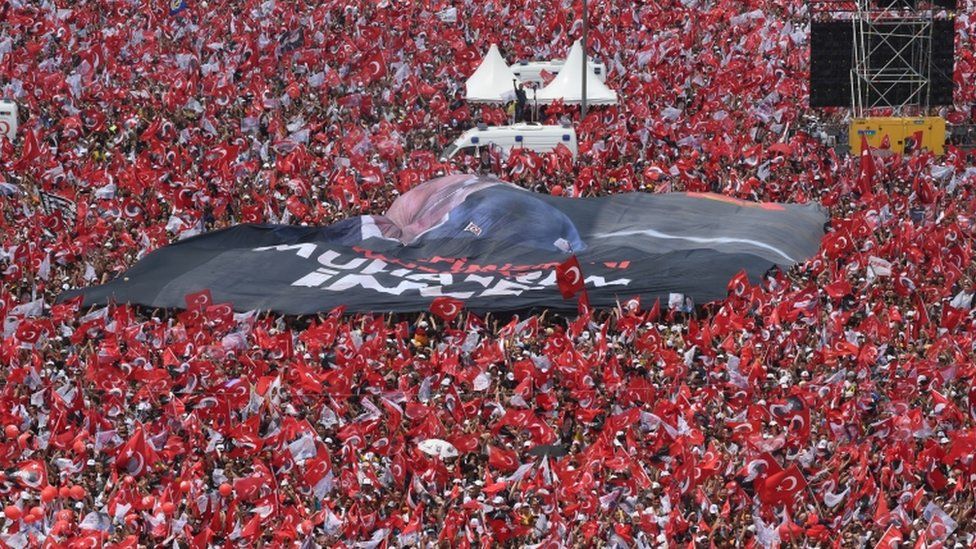 Thousands of supporters wave flags and cheer as they listen during an election rally for Muharrem Ince