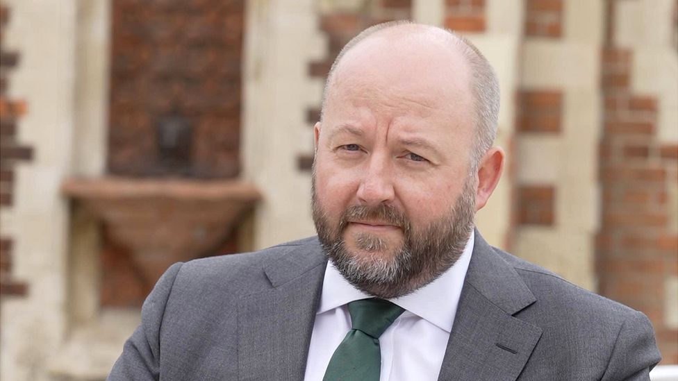 Nick Timothy is pictured wearing a grey suit and green tie