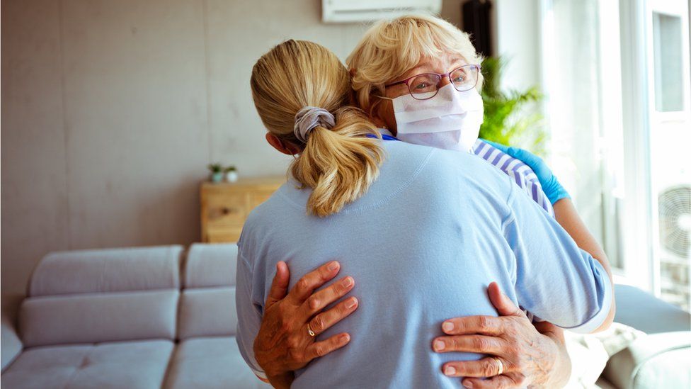 Stock photo of a nurse embracing an elderly woman