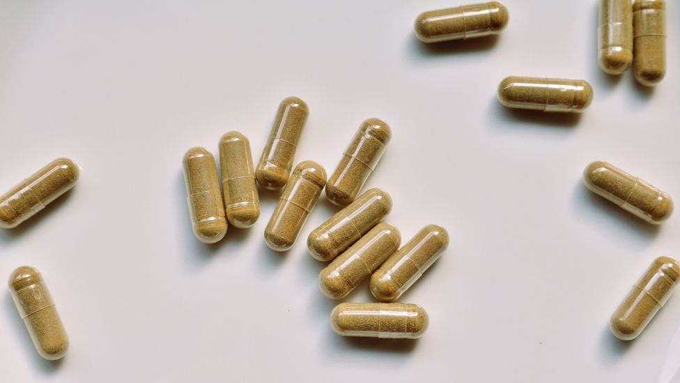 green tea supplement capsules scattered on a table