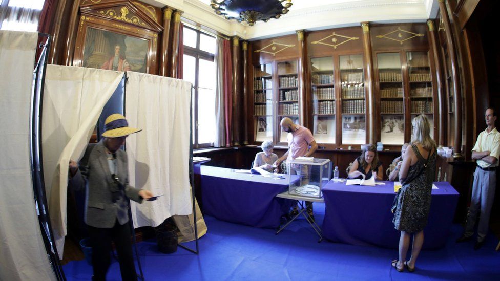 A person leaves a polling booth during the first round of French parliamentary election in Nice