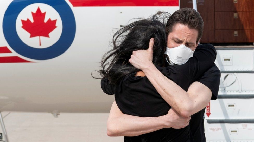Бывший дипломат Майкл Ковриг обнимает свою жену Вину Наджибуллу после прибытия в Торонто