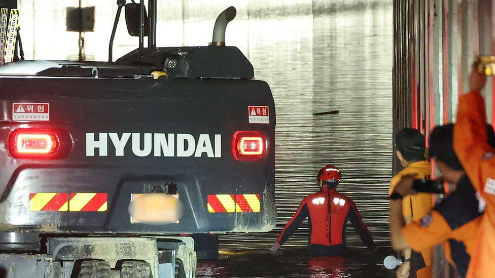 Rescue workers search for missing people in a flooded underground tunnel in the town of Osong, North Chungcheong Province, central South Korea, on 17 July 2023, as 15 vehicles and several people are believed to have been submerged inside the tunnel after a nearby river overflowed due to heavy rain on 15 July.