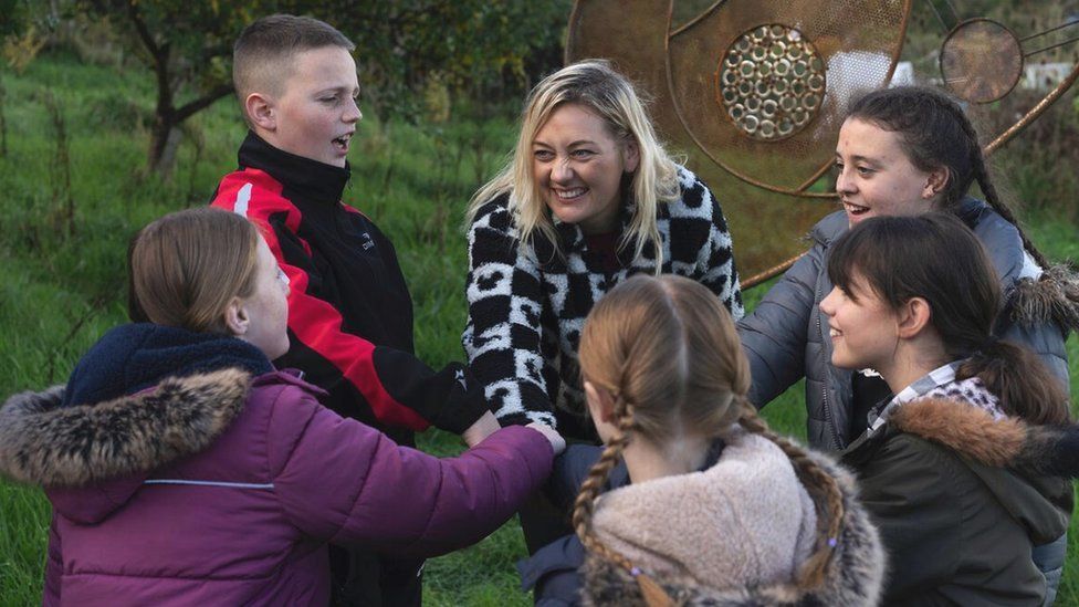 Image of Kirsty Hammond with several of the children in the group