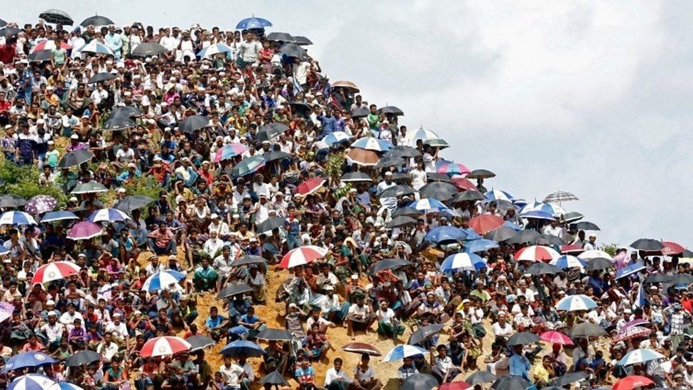 Hundreds of people can be seen crowding a hilltop