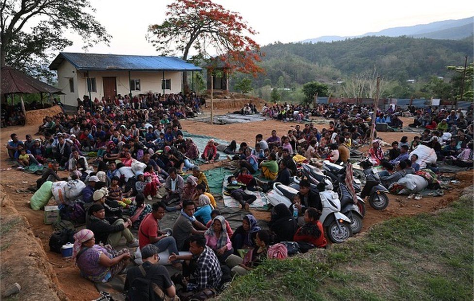 People wait at a temporary shelter in a military camp, after being evacuated by the Indian army, as they flee ethnic violence in the northeastern state of Manipur on May 7, 2023