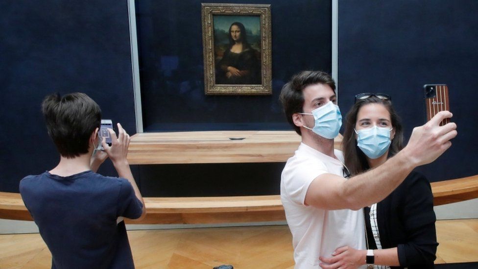 Tourists take a selfie in front of the Mona Lisa
