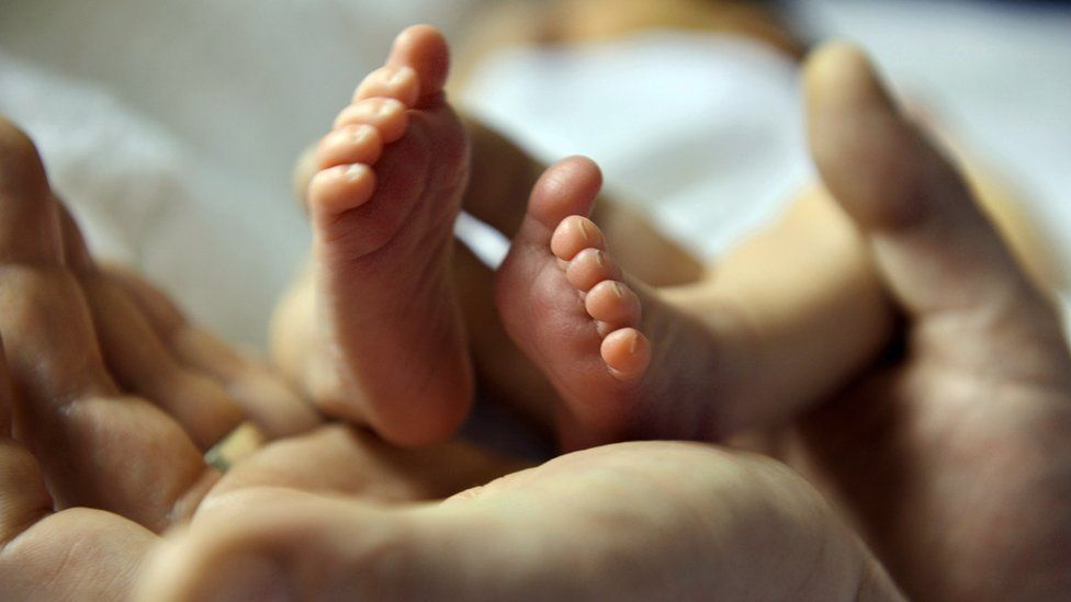 Baby's feet held in hands