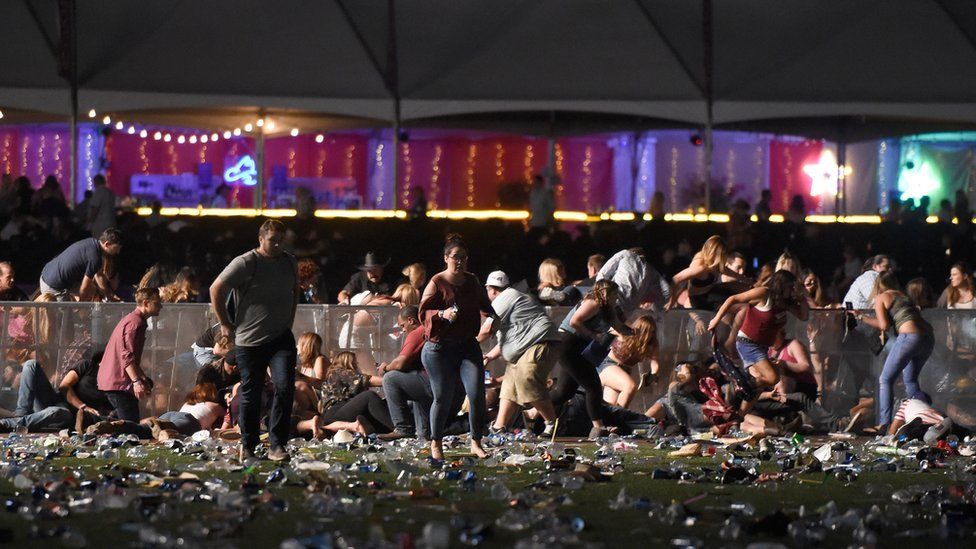 People run from the Route 91 Country Music Festival in Las Vegas after shooting begins