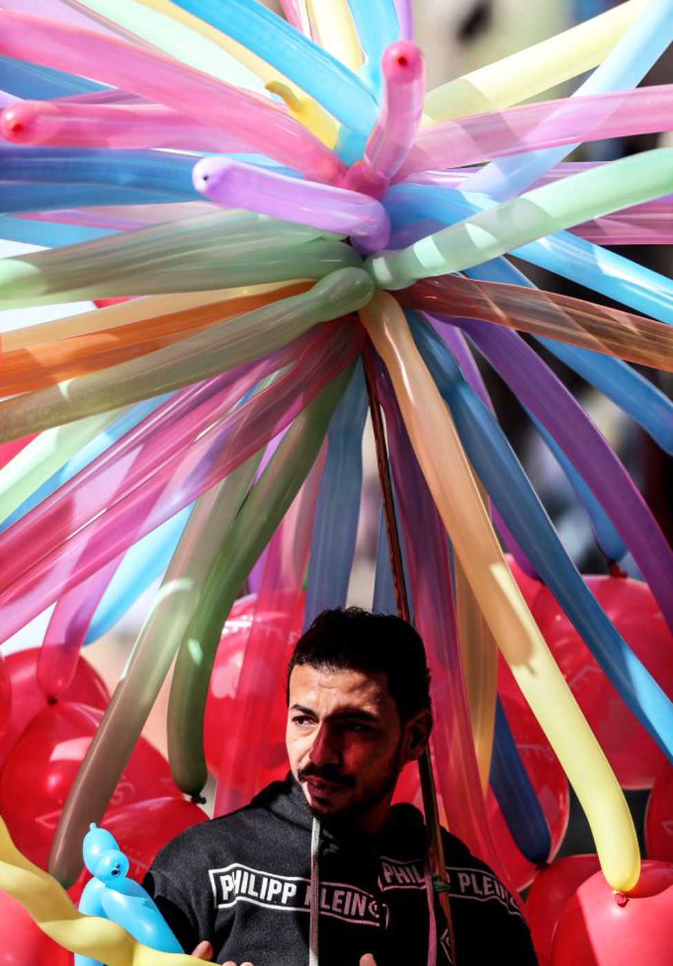 Man under an 'umbrella' of balloons
