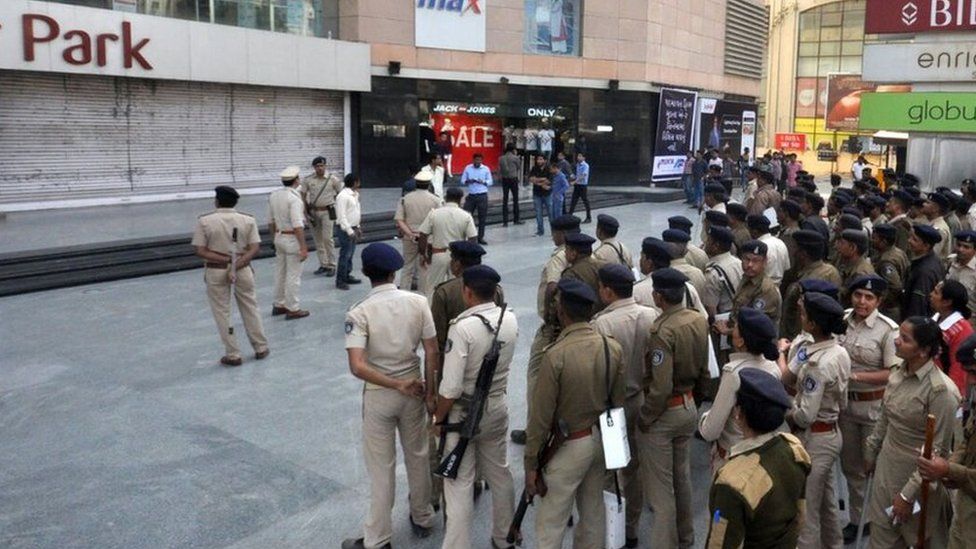 Police stand guard outside a mall in Gujarat