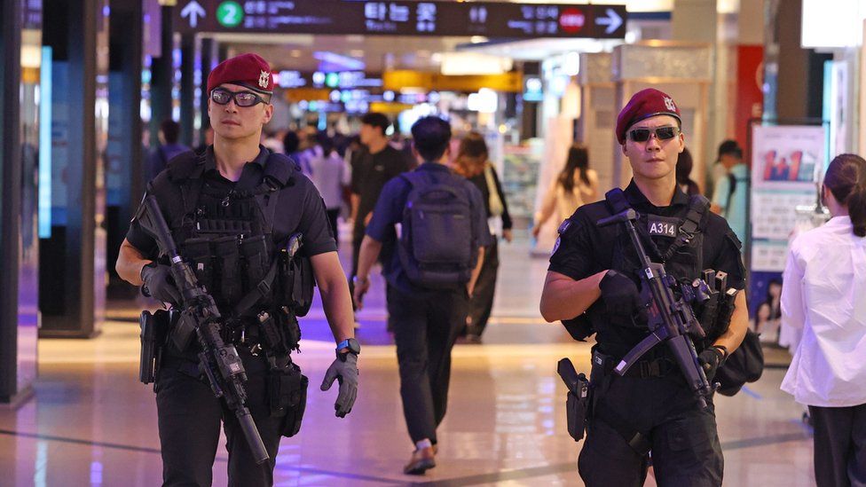 Heavily armed police patrol a Seoul shopping strip on 5 August, the weekend after a mass stabbing