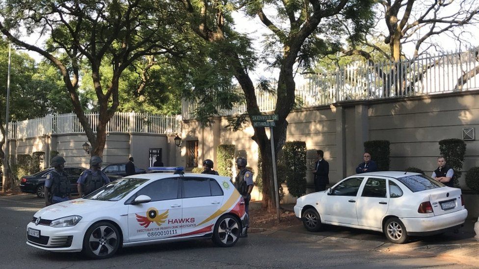 Members of the Hawks special police unit stand guard outside Gupta home