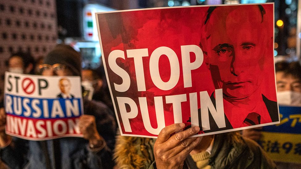 People hold up placards as they take part in a protest against Russia's actions in Ukraine, during a rally near the Russian Embassy in Tokyo on 4 March 2022