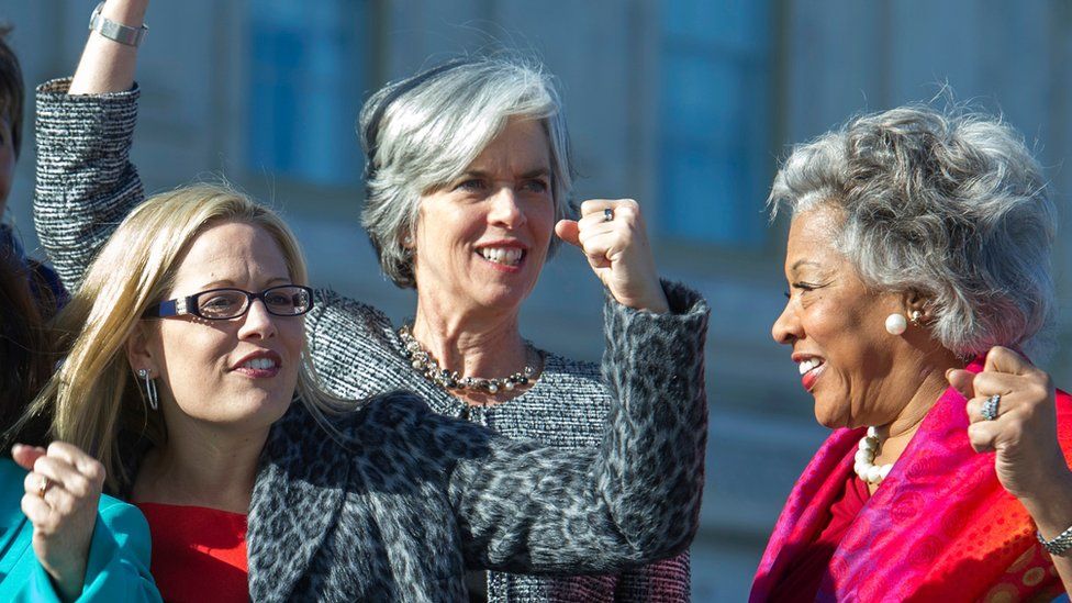 From left, Rep. Kyrsten Sinema, D-Ariz., Rep. Katherine Clark, D-Mass., and Rep. Joyce Beatty, D-Ohio, raise fists during a photo opportunity with the Democratic women of the House, Wednesday, Jan. 4, 2017,