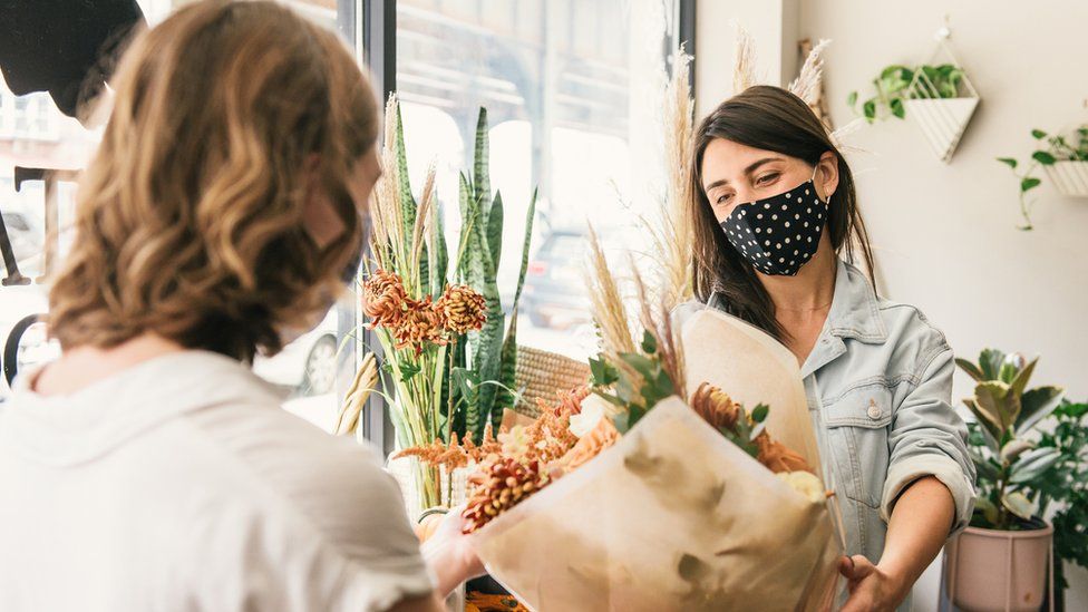 Woman wearing face mask in flower shop