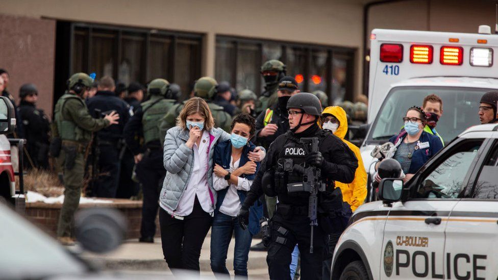 Healthcare workers walk out of a King Sooper's Grocery store after a gunman opened fire on 22 March 2021 in Boulder, Colorado