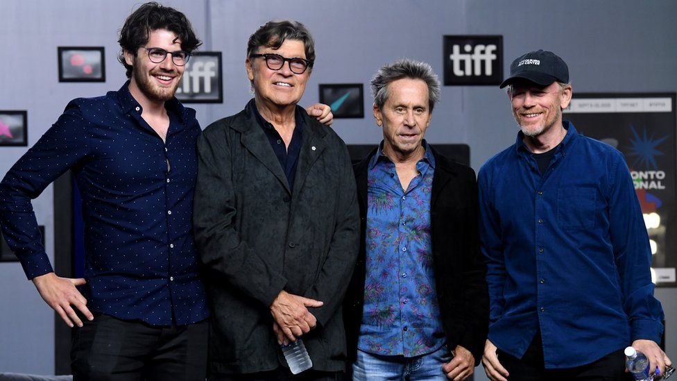 Daniel Roher, Robbie Robertson, and exec producers Brian Grazer and Ron Howard
