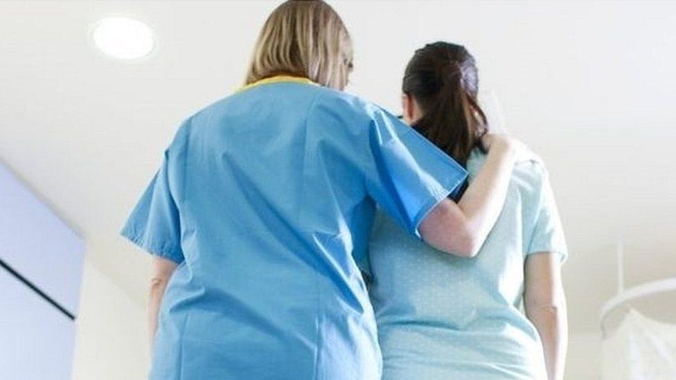 Woman being comforted by a nurse in a hospital