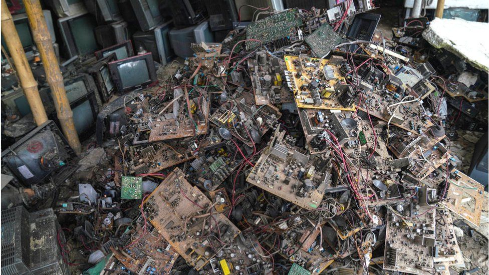 Old TV components are discarded inside at a TV recycling scrap yard in Dhaka