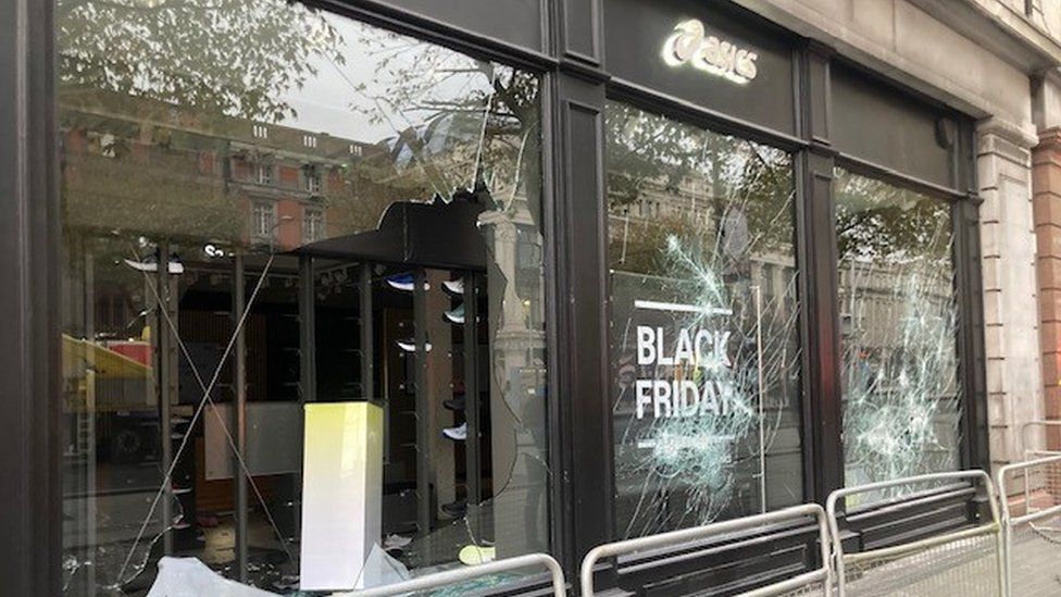 An Asics sports clothing store with a broken window