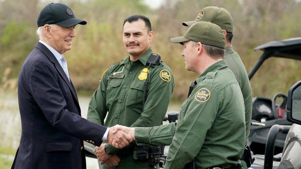 President Joe Biden shakes hands with a US border official