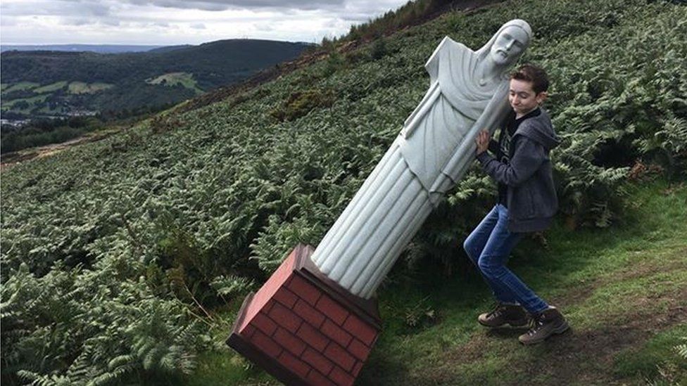 Tyler, 12, helping take the statue up the mountain