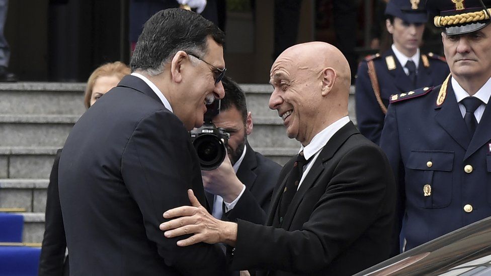 Marco Minniti (R) greets Libya's Prime Minister Fayez al-Sarraj