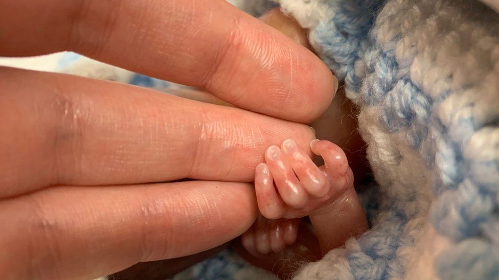 Elan Arfor Connor's hand holding baby Elis' hand