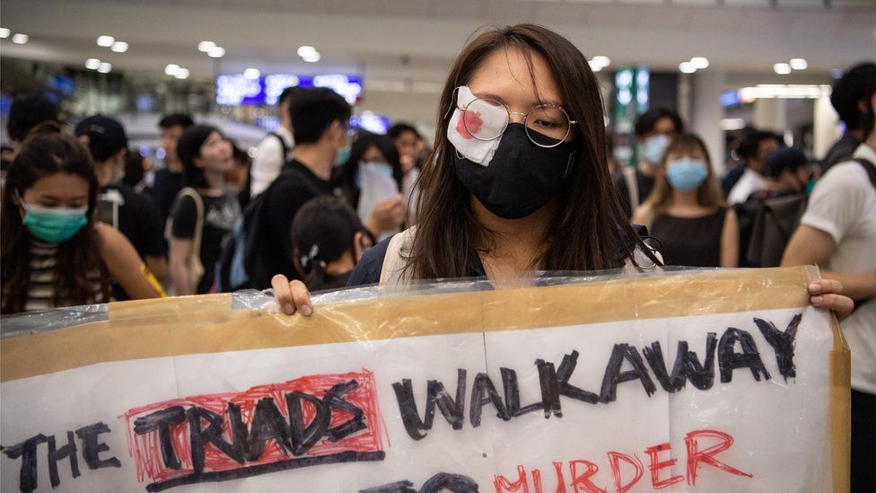 A woman wears an eye patch to protest police violence during a sit-in at Hong Kong Chek Lap Kok International Airport, Hong Kong