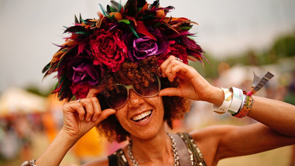 A woman wearing a flower headdress during the Glastonbury Festival