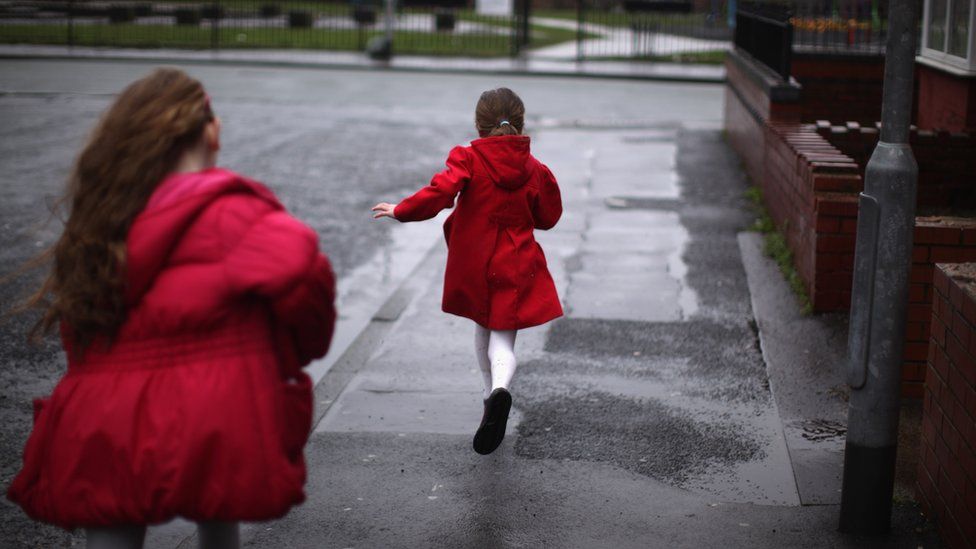 Two children run in the street