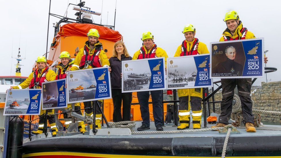 Bridget Yabsley (centre), head of philatelic at Guernsey Post, and RNLI Guernsey crew with the commemorative stamps