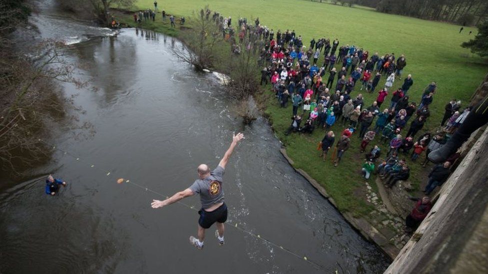 A man takes part in the Mappleton Bridge Jump, an annual unofficial tradition where those willing jump from Okeover bridge on New Years Day into the River Dove in Mapleton, Derbyshire.