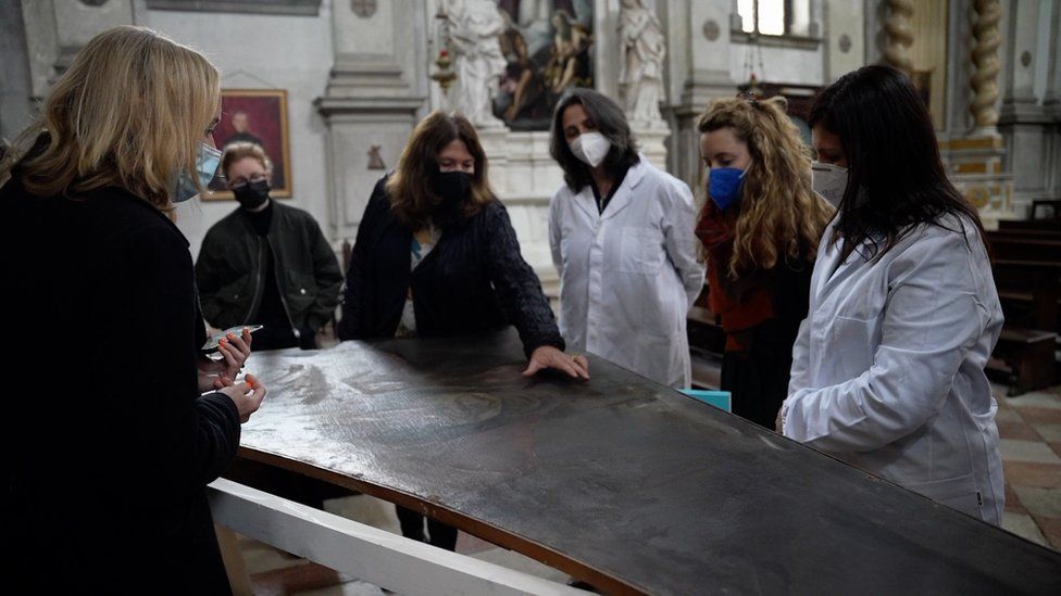 Art historian Cleo Nisse (second right), Melissa Conn from Save Venice (third left) and conservators assess a Giulia Lama canvas